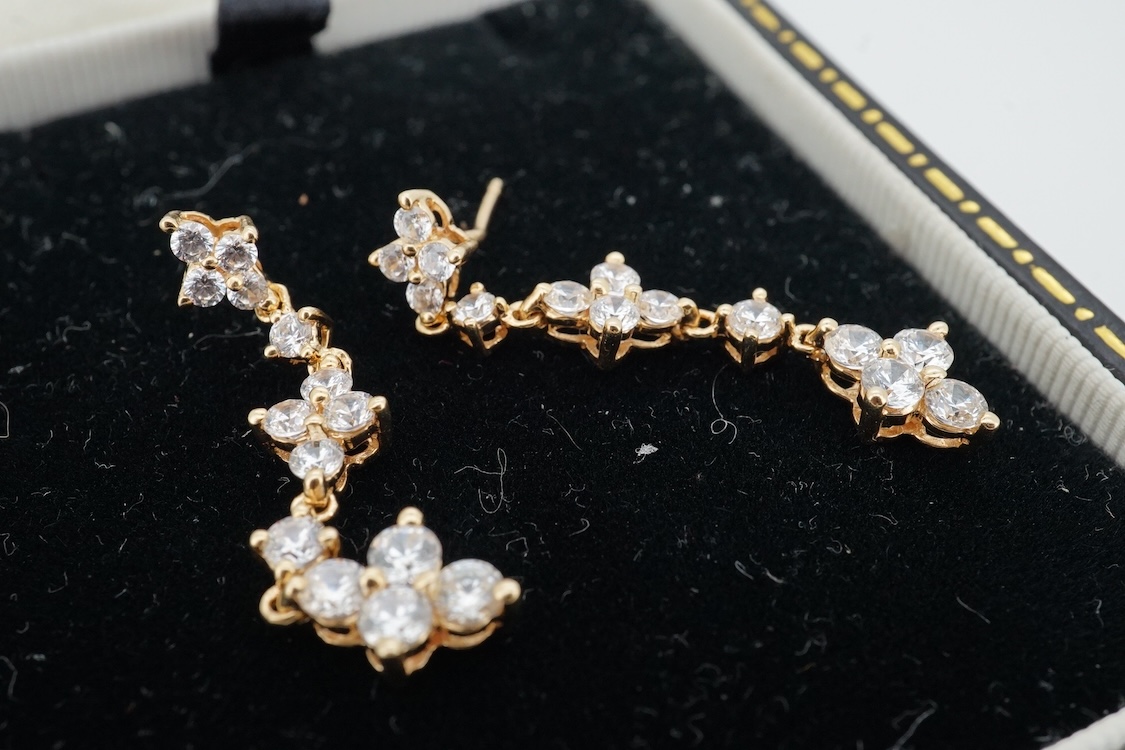 A modern yellow metal (stamped 585) and cubic zirconia set line bracelet, 18cm and a pair of similar drop earrings, together with a similar 9k and cubic zirconia set cluster ring, size N.